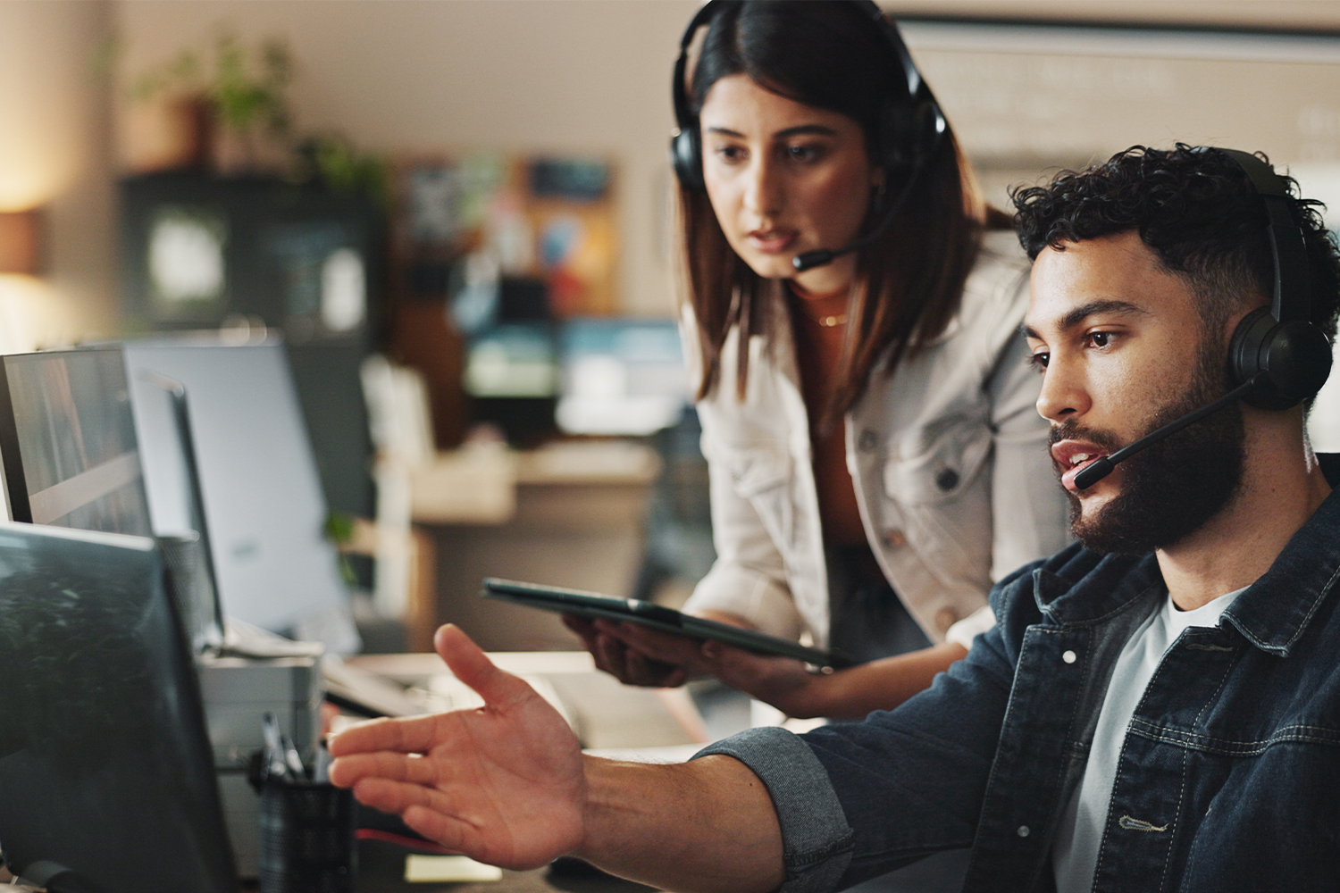 people with headset talking and staring at the computer screen