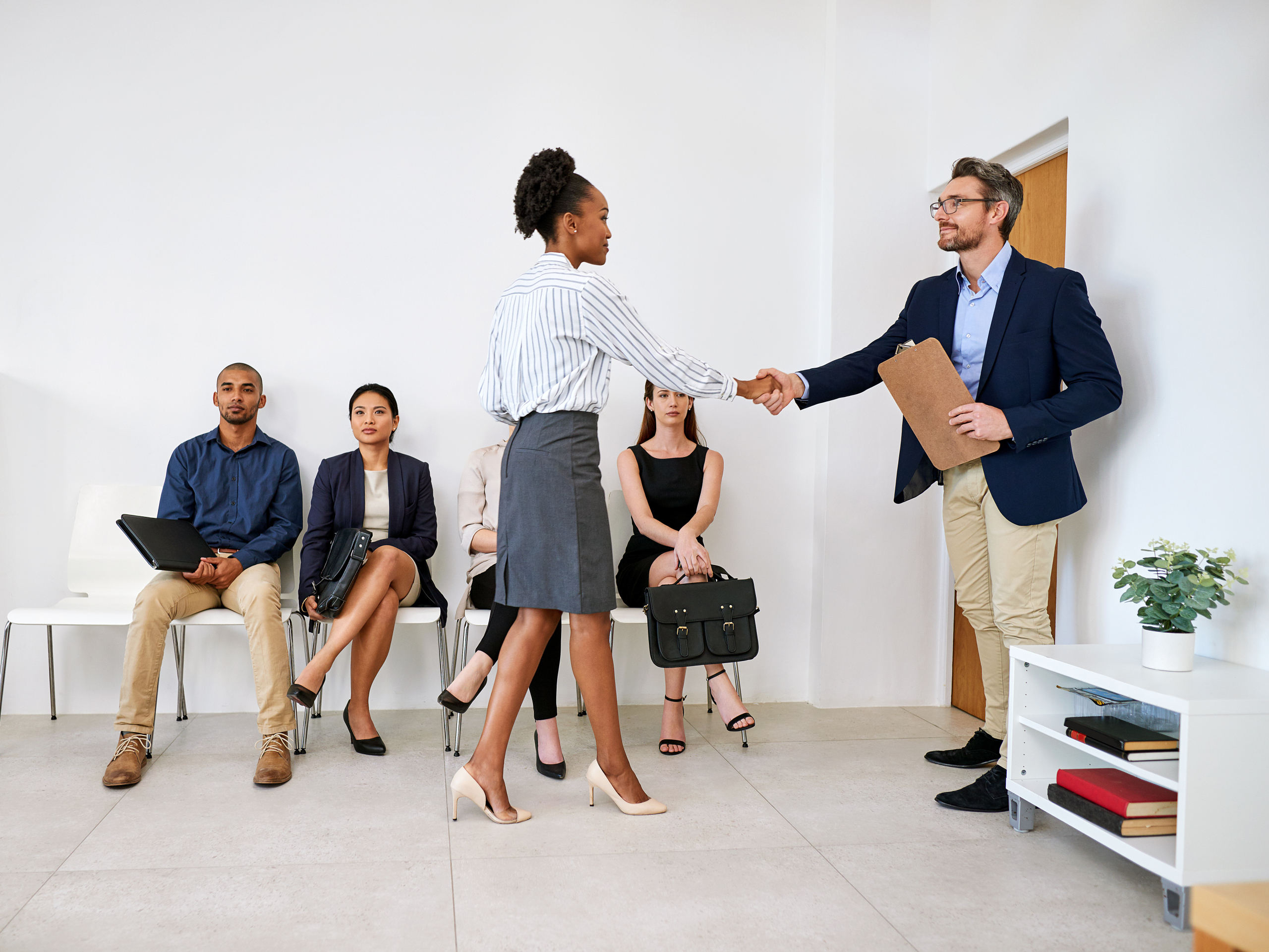 Shot of a group of businesspeople seated in line while waiting to be interviewed.